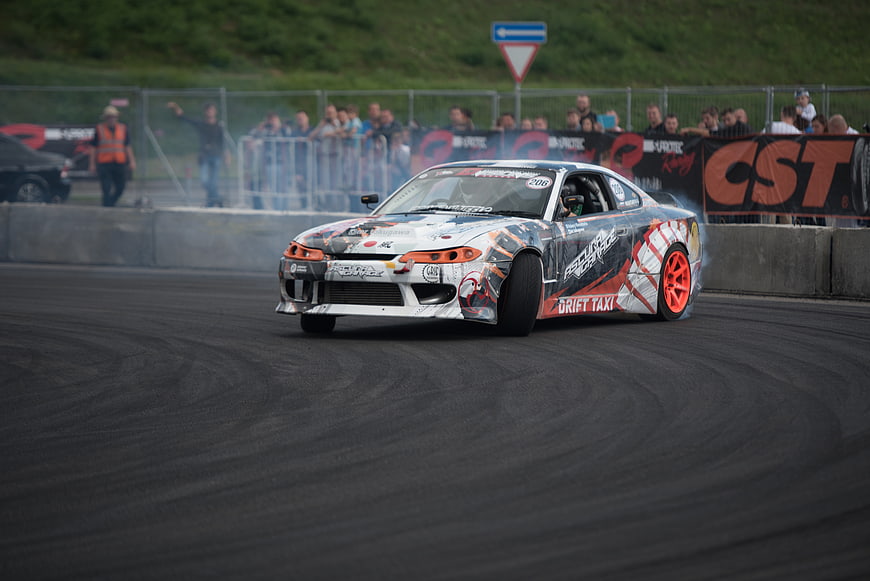 Drift car racing on track with smoke and crowd