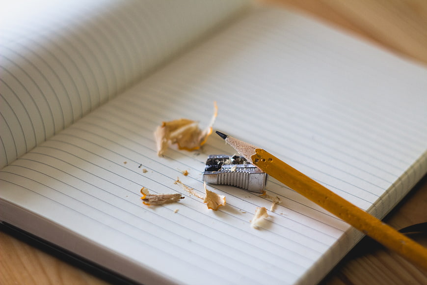 Yellow pencil and sharpener on open notebook