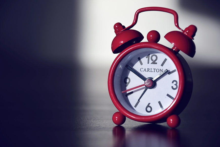Red Carlton Alarm Clock on Dark Surface