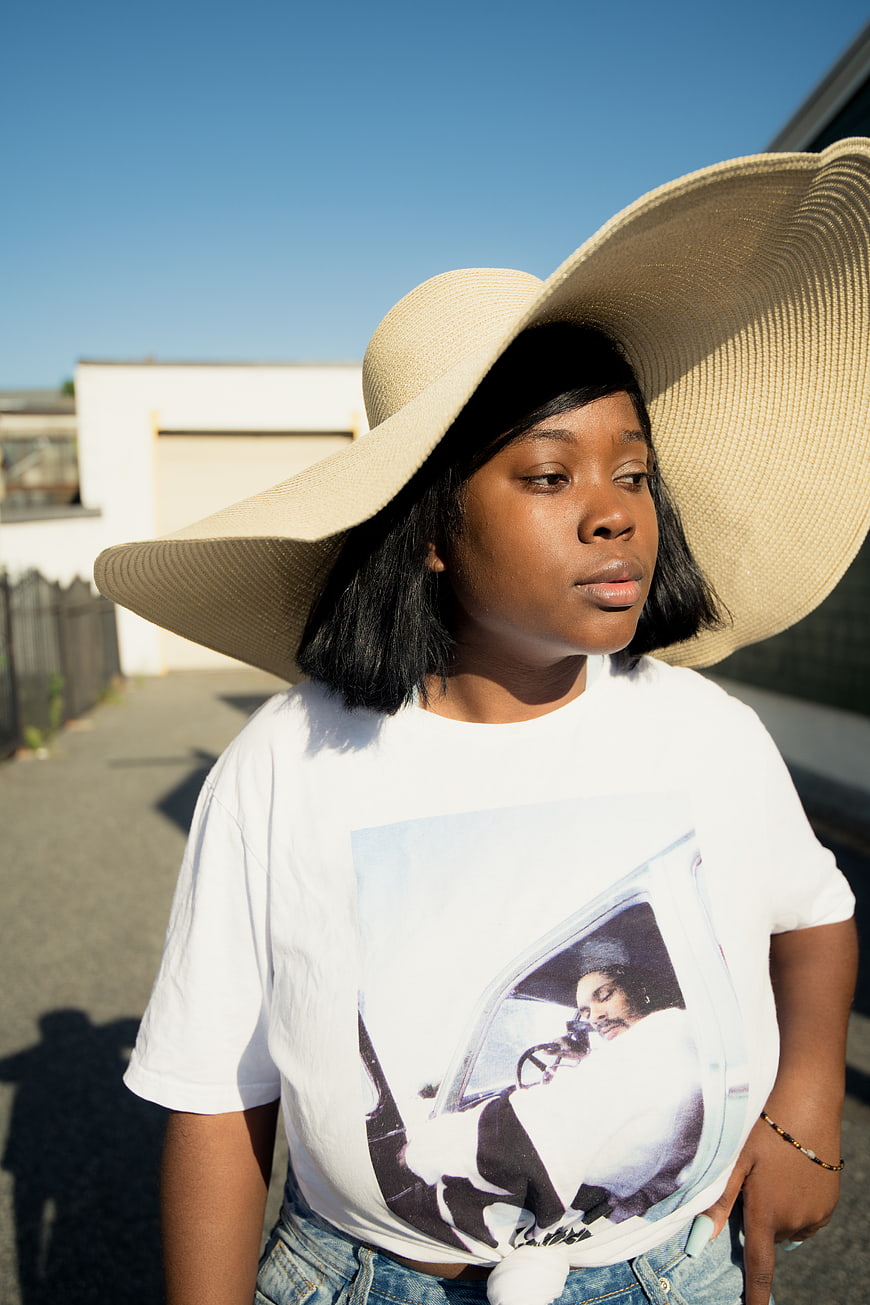 Stylish Black Woman in Oversized Straw Hat and Graphic Tee
