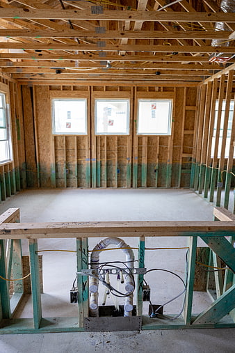 Interior framing of new home construction with exposed pipes