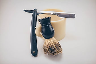 Vintage straight razor and shaving brush on white background
