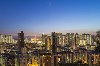 Cityscape at Twilight with Crescent Moon and City Lights