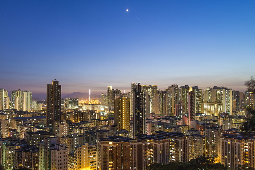 Cityscape at Twilight with Crescent Moon and City Lights