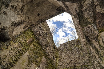 Low angle view of ancient stone castle ruins looking up at sky