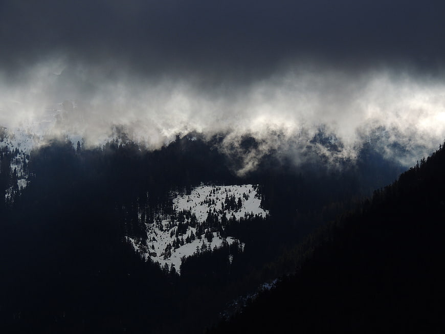 Dramatic Snowy Mountain Peak Shrouded in Dark Fog