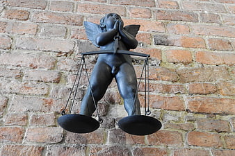 Bronze Angel Sculpture with Scales on Brick Wall