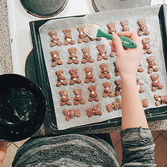 Top view of baking gingerbread bear cookies with almonds