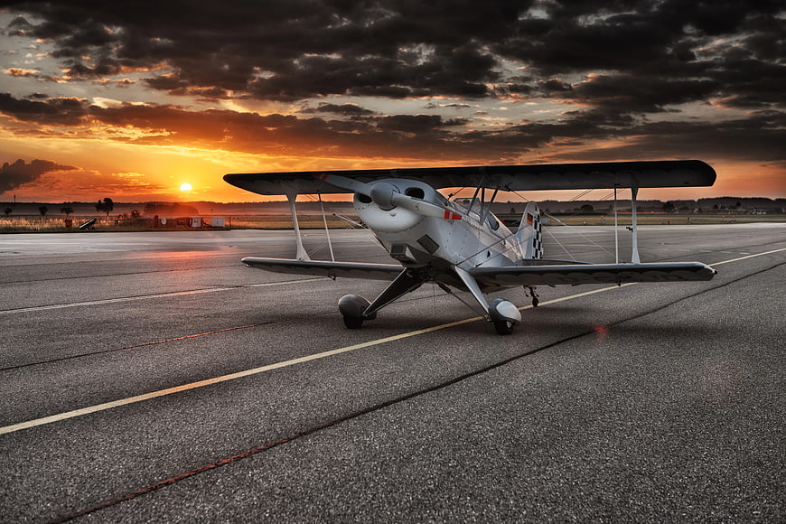 Small Propeller Plane on Runway at Sunset