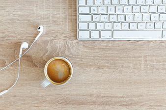 Top View of Coffee, Earphones, and Keyboard on Wooden Desk