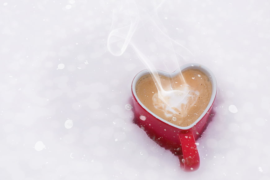 Steaming Heart-Shaped Coffee Cup in Snow