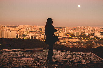 Silhouette of Woman Looking at City Skyline at Dusk