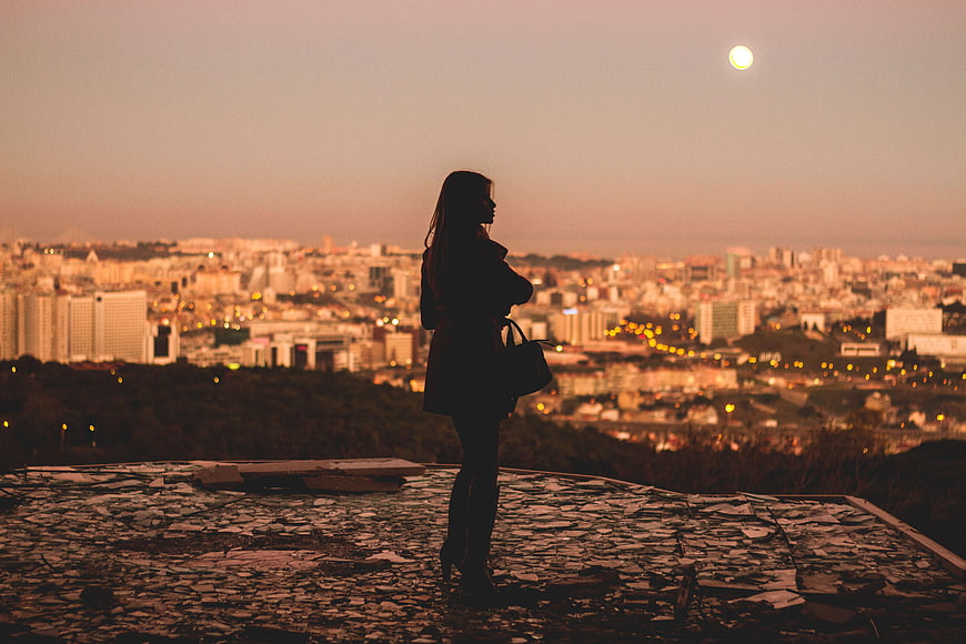 Silhouette of Woman Looking at City Skyline at Dusk