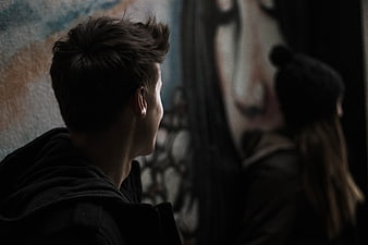 Young Man and Woman Looking at Street Art Mural