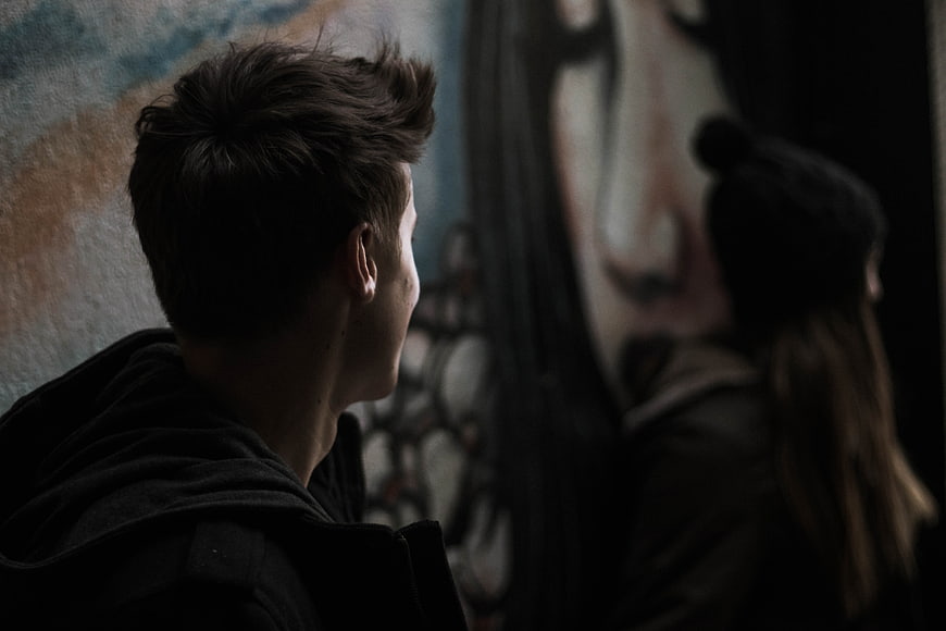 Young Man and Woman Looking at Street Art Mural