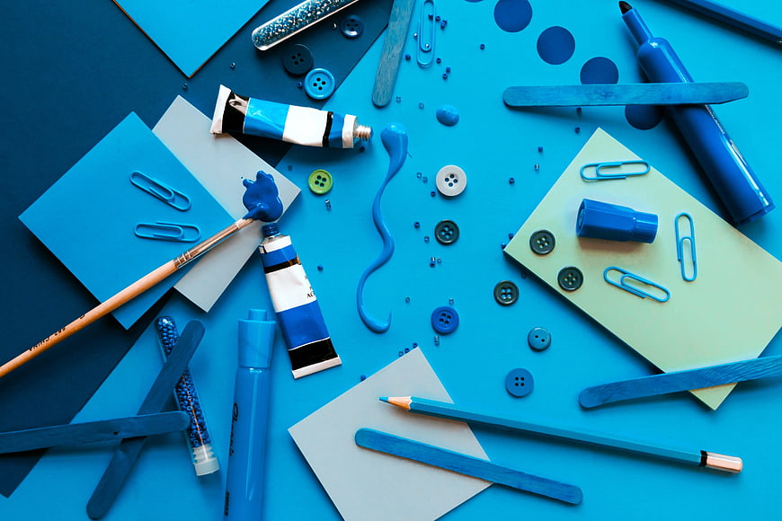 Blue monochrome art supplies flat lay with paint and paper