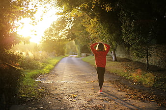 Woman stretching on autumn road at sunrise