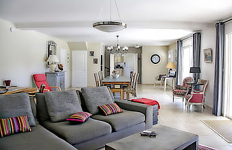 Spacious modern living room with gray sofa and dining area