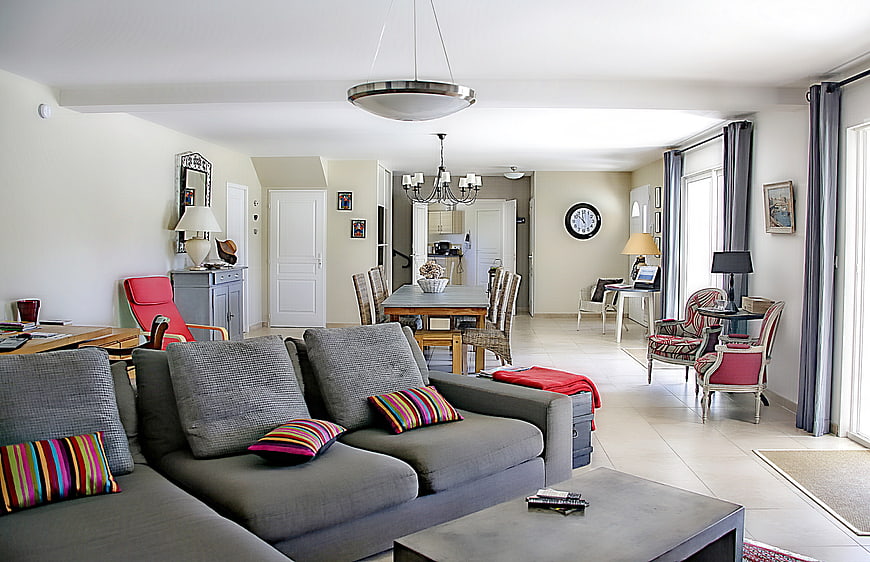 Spacious modern living room with gray sofa and dining area