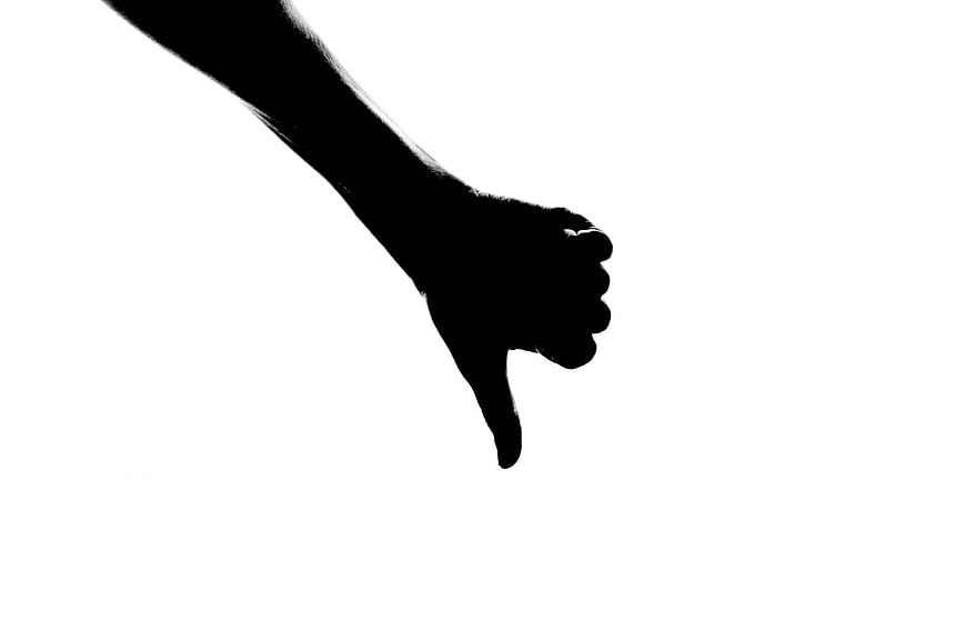 Silhouette of Hand Giving Thumb Down Gesture on White Background