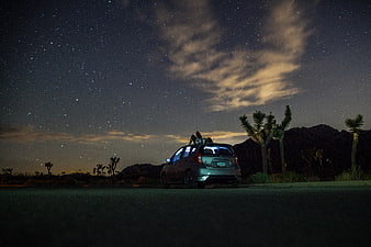 Couple Relaxing on Car Roof Under Starry Night Sky