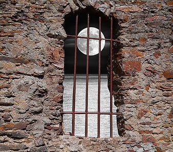 Full Moon Viewed Through Rusty Iron Bars In Stone Wall