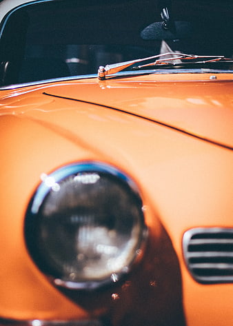 Close-up of vintage orange car hood and headlight