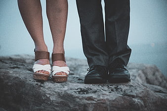 Couple's Feet Standing on Rocky Cliff Edge