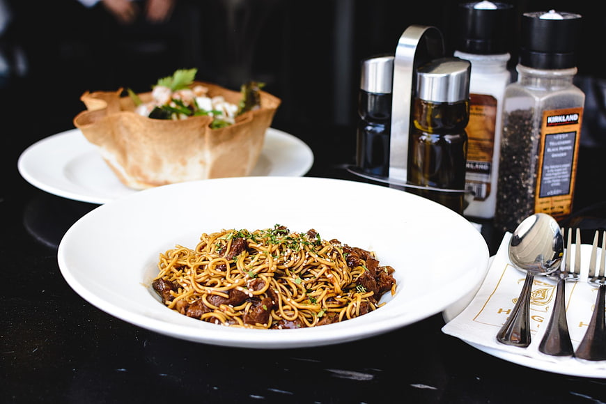 Beef oyster sauce noodles with salad and condiments