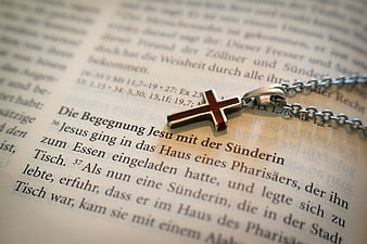 Silver Cross Necklace on German Bible Page