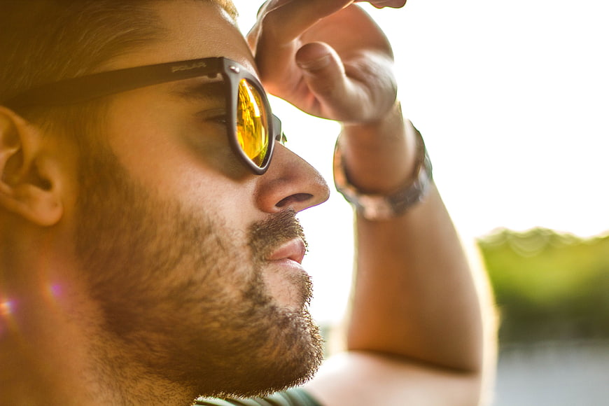 Close-up of man wearing sunglasses in bright sunlight