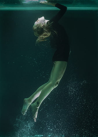 Underwater Portrait of Woman Floating in Dark Water