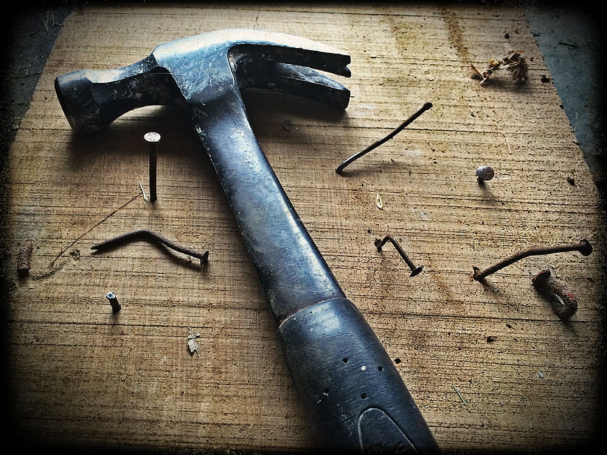 Vintage Claw Hammer and Bent Nails on Wooden Plank
