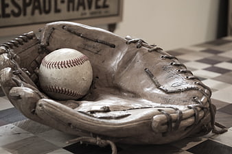 Vintage baseball glove and ball on checkered floor
