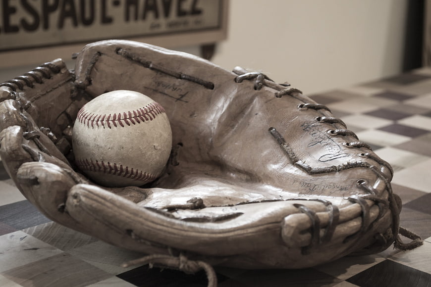 Vintage baseball glove and ball on checkered floor