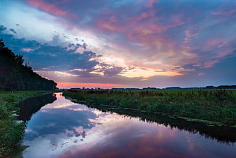 Dramatic Sunset Reflection Over River in Dutch Landscape