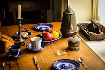 Vintage rustic breakfast table with blue china and fruit