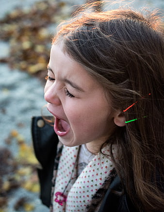 Close-up of a young girl crying outdoors in autumn