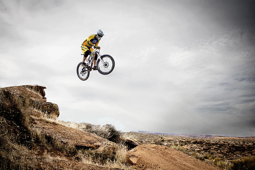 Mountain Biker Jumping in Desert Canyon