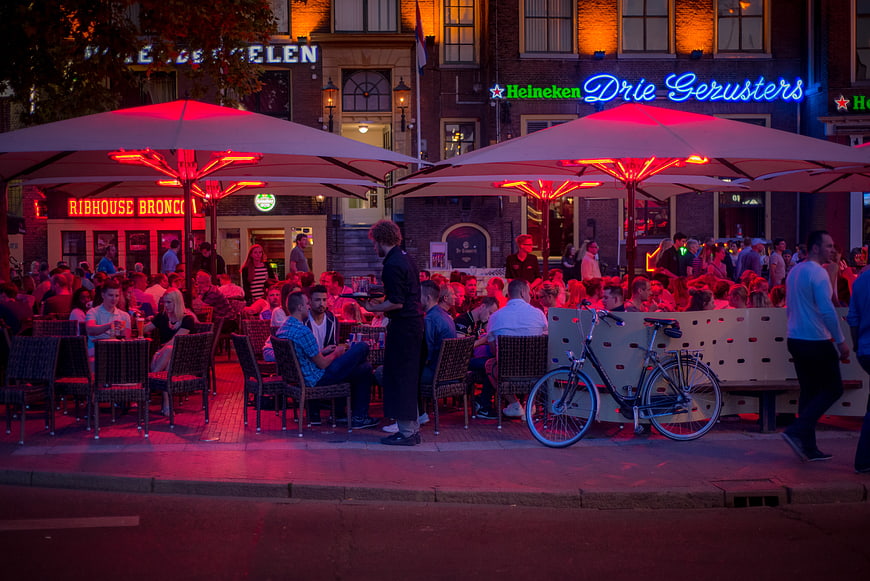 Bustling Dutch Cafe Terrace at Night with Neon Lights