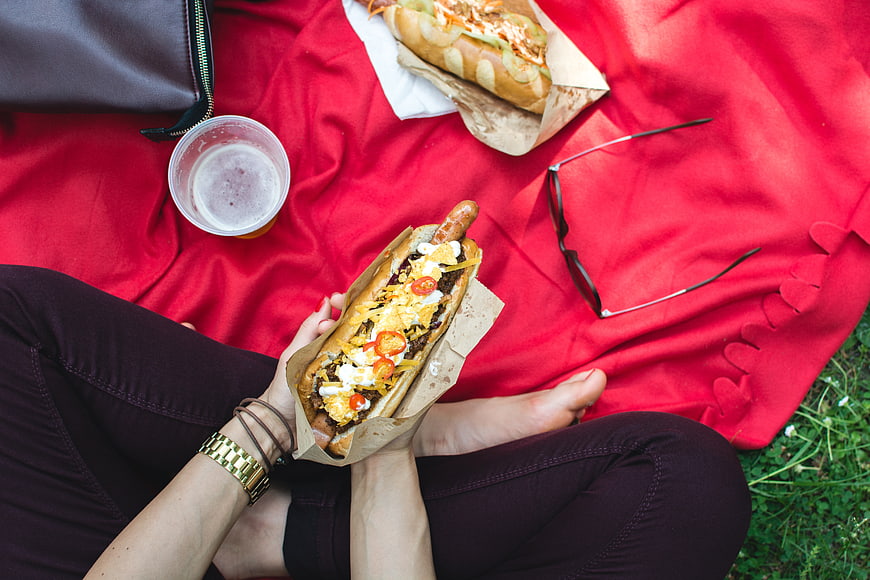 Top View of Gourmet Hot Dog Picnic on Red Blanket