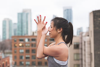 Asian woman doing yoga on urban rooftop