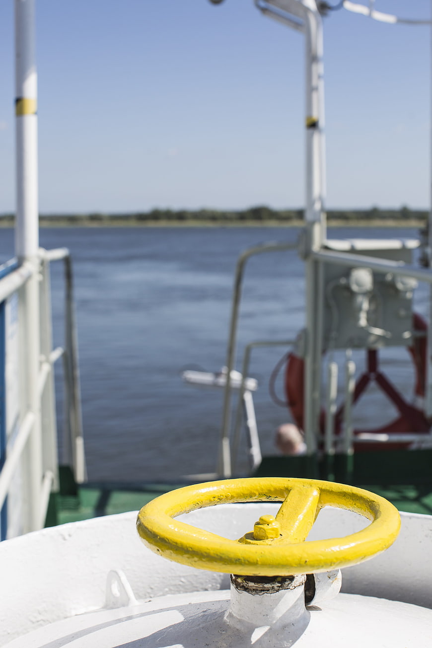 Yellow valve wheel on ferry deck with river background