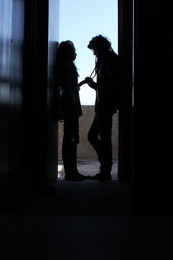Silhouette of couple holding hands in doorway