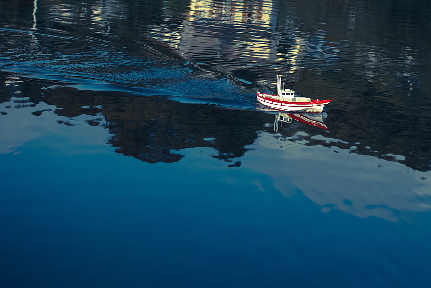 Aerial view of red and white model boat on blue water