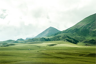 Serene Green Mountain Landscape with Rolling Hills and Cloudy Sky