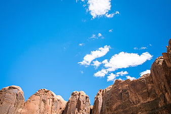Red Rock Cliffs Against Blue Sky with White Clouds