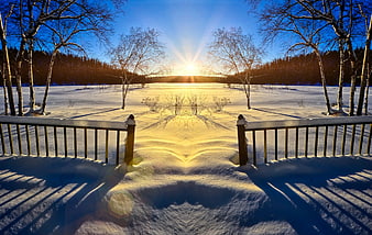 Symmetrical Winter Sunrise Over Snowy Lake With Wooden Bridge