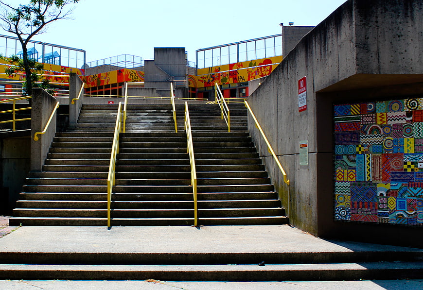 Concrete Staircase with Yellow Rails and Colorful Mosaic Art