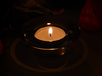 Glowing Tea Light Candle in Glass Holder at Night